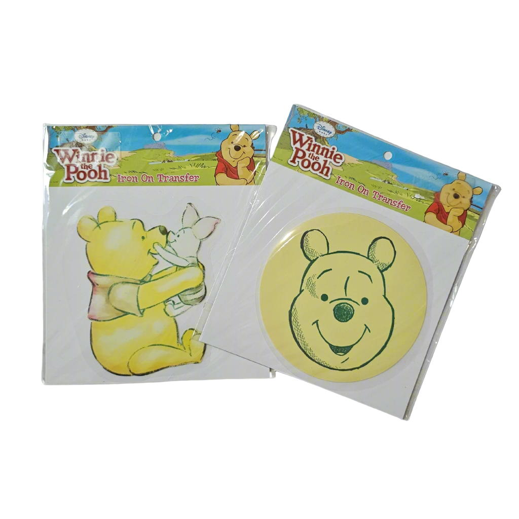 Two packages of Winnie-the-Pooh iron on transfers, one depicting Winnie-the-Pooh holding a honey pot and the other with Winnie-the-Pooh's face silhouette.